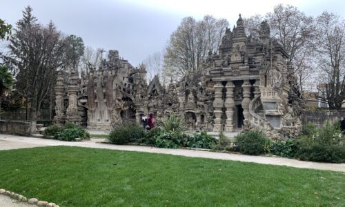 People walking by Le Palais Idéal in Hauterives, France.