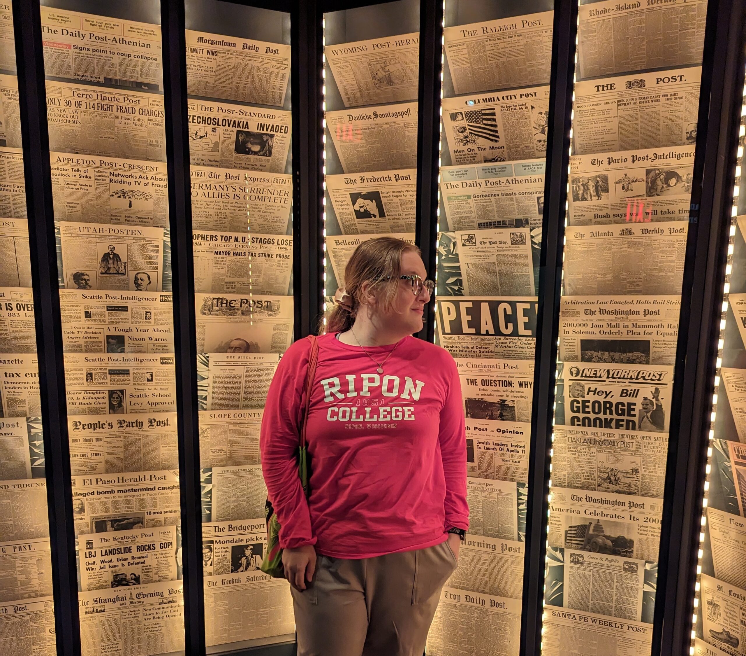 Caitlin stands in front of newspapers archived at the Smithsonian National Postal Museum. Photo courtesy of Samantha Dietel.